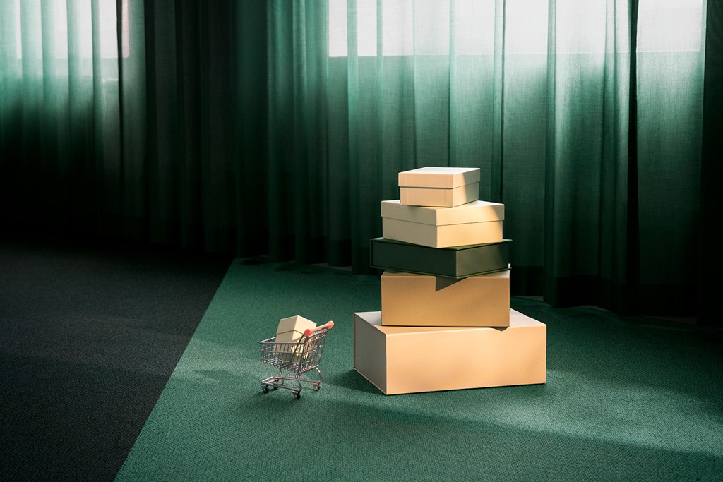 Stablede esker og en liten handlevogn på grønt teppe i mykt lys.